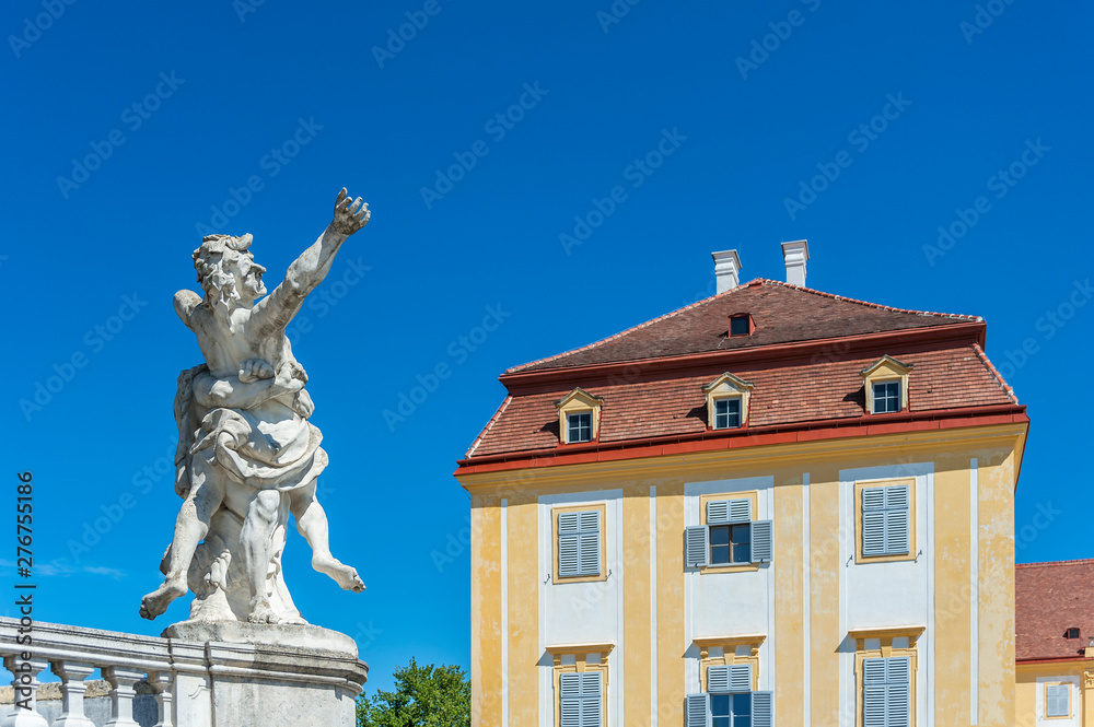 Baroque statue in a park with historical building