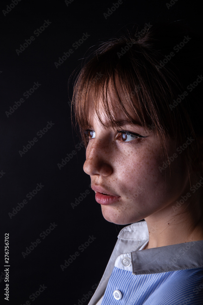 Close-up shot of a young caucasian girl face with freckles