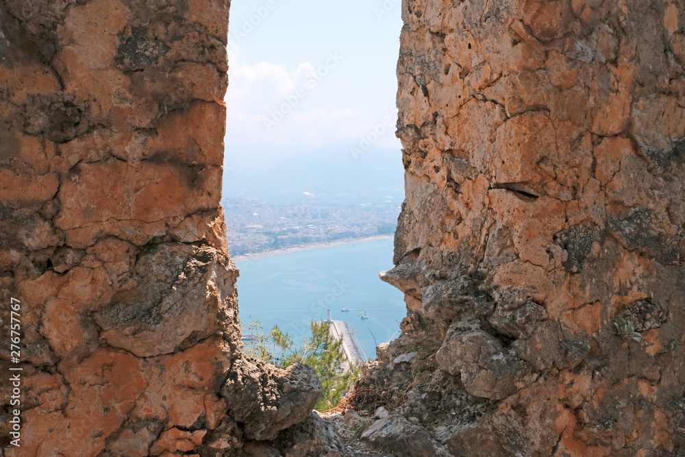 View of the fortress, the ruins on the Peninsula of Alanya, Turkey, Asia.Mediterranean sea, beautiful background. Famous tourist destination with high mountains. Part of an ancient Old castle.