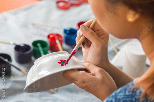 Close-up hands holding a bowl during painting in Lampang province, Thailand