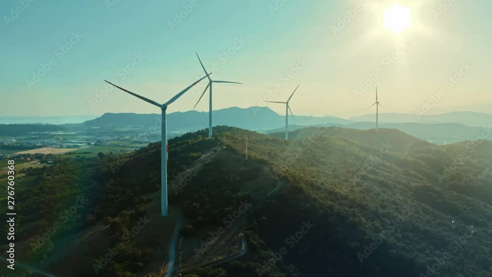Wind turbine farm on beautiful purple evening mountain landscape. Renewable energy production for green ecological world. 4k