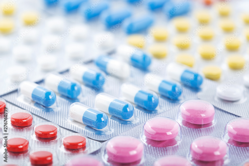 Heap of medical pills in white, blue and other colors. Pills in plastic package. Concept of healthcare and medicine. Heap of medical pills in white, blue and other colors. Pills in plastic package. Concept of healthcare and medicine.