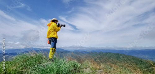 Tourists stand to take pictures at the viewpoint with mountains and beautiful skies