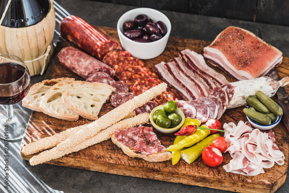 Variety of appetizer on wooden board, wine snack set with prosciutto, salami, ham, olives. 
