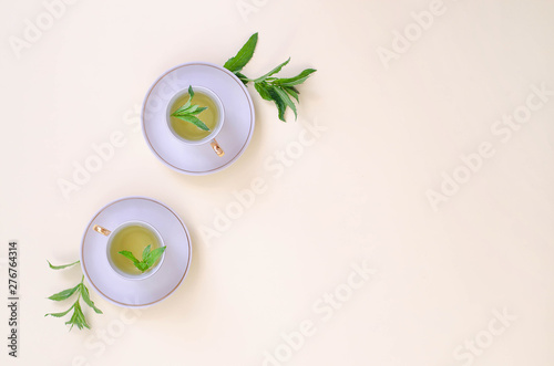 Two cups of mint tea on a light yellow background.
