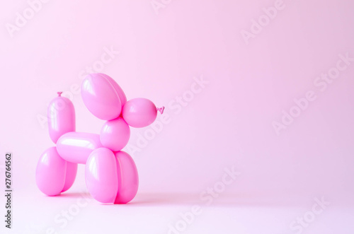 Balloon in the form of a dog on a pink background.