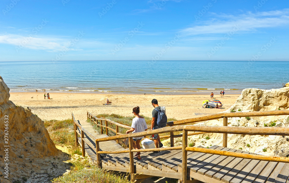 Φωτογραφία Una pareja caminando por la pasarela de madera hacia la playa de Asperillo, muy cerca del Parque Nacional de Doñana, provincia de Huelva, Andalucía, España
