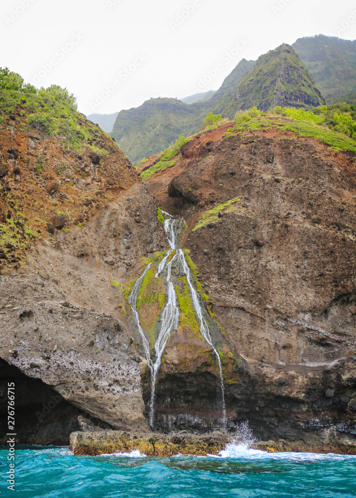 Φωτογραφία Waterfall coming off the cliff into the ocean along the Napali Coast, the north shore of Kauai