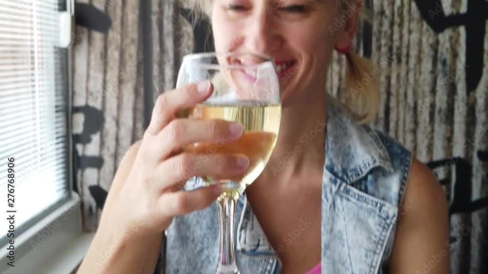 Smiling caucasian modern woman drinking white sparkling wine in an asian restaurant. Defocused background in slow motion. Lifestyle adult in SLOW MOTION. Smiling caucasian modern woman drinking white sparkling wine in an asian restaurant. Defocused background in slow motion. Lifestyle adult in SLOW MOTION.