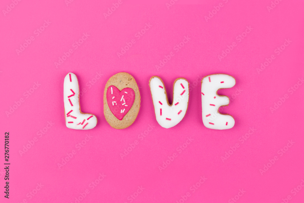 Gingerbread in the shape of the word love on a pink background. Flat lay, top view.
Gingerbread in the shape of the word love on a pink background. Flat lay, top view.