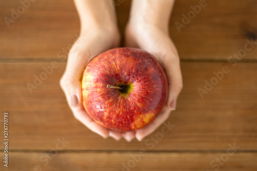 Wallpaper Mural food, diet and people concept - close up of hands holding ripe red apple over wooden table Torontodigital.ca
