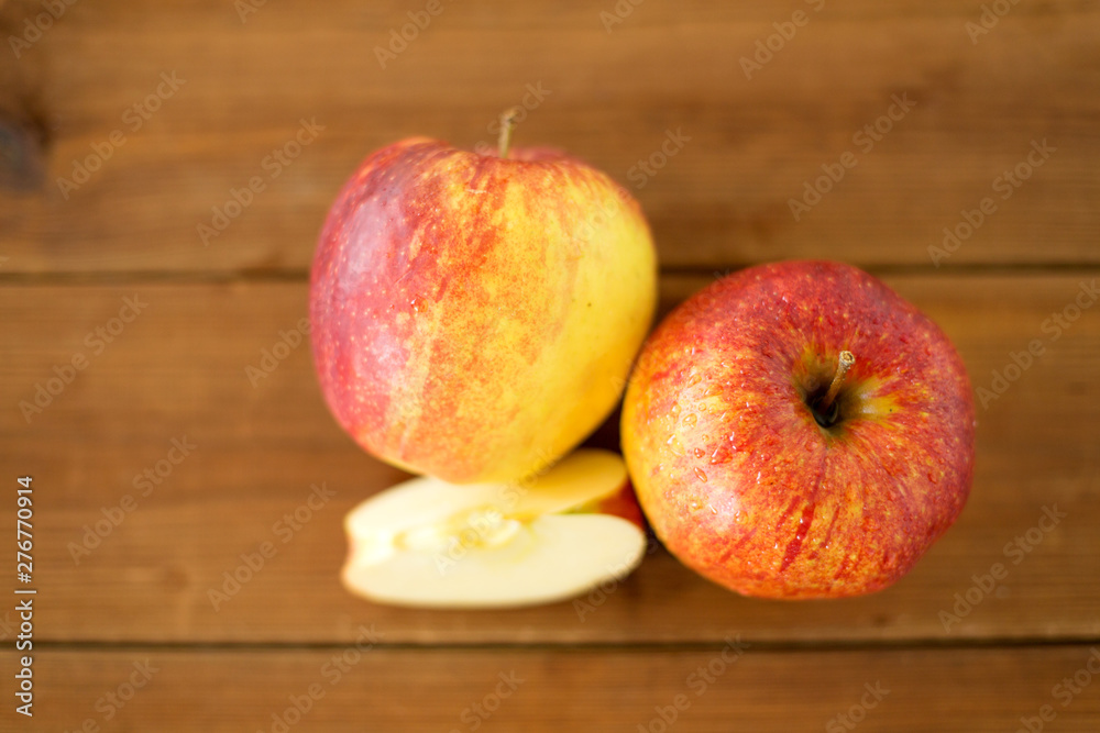 fruits, food and harvest concept - ripe red apples on wooden table