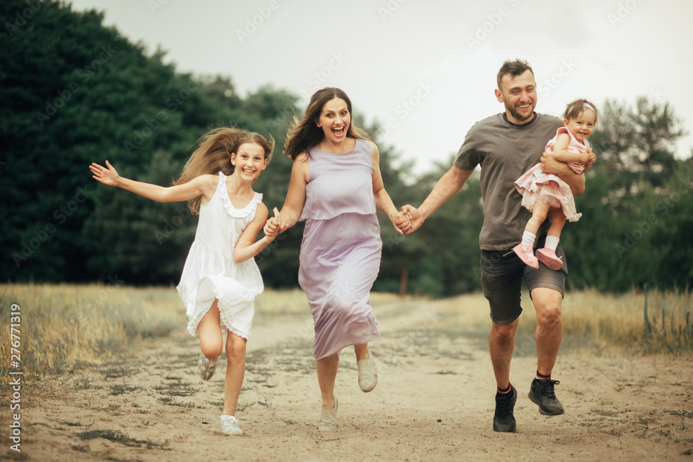 Happy family has fun, runs and laughs on a walk. Happy family has fun, runs and laughs on a walk.