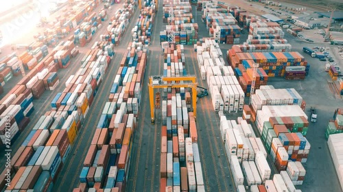 Cargo containers in busy port, aerial hyperlapse. Shipping harbor, logistics, loading and unloading of ships. Export and import of goods photo