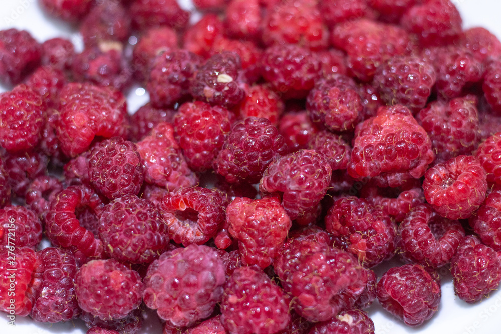 Red Raspberries in a square wooden pint container full isolated on white. Red raspberries in a white container. Red raspberry close-up Red Raspberries in a square wooden pint container full isolated on white. Red raspberries in a white container. Red raspberry close-up