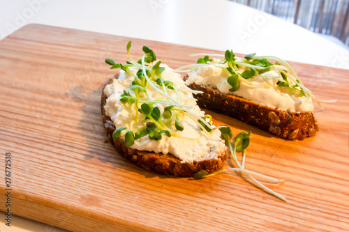 Rye bread with curd radish on a brown wooden board