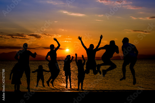 silhouette of friends jumping on beach during sunset time