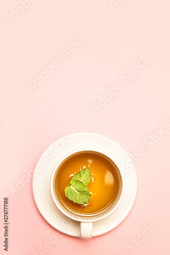Creative concept of white ceramic cup with herbal green or black tea with mint leaves
