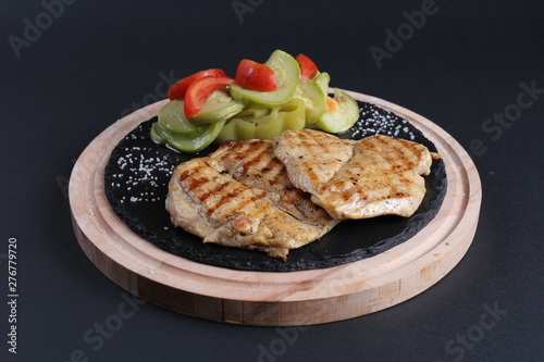 Chicken grill, tomato, green pepper on black background.