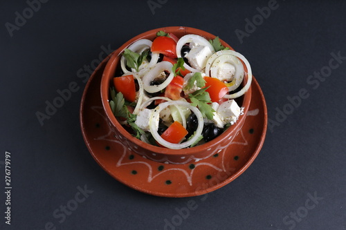 Salate with cheese, tomato, onion, olive,vegetable, diet on black background.