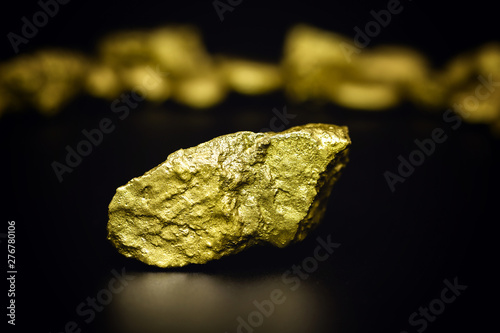 Golden stone in high resolution. Gold on black background isolated. Concept of luxury and wealth.