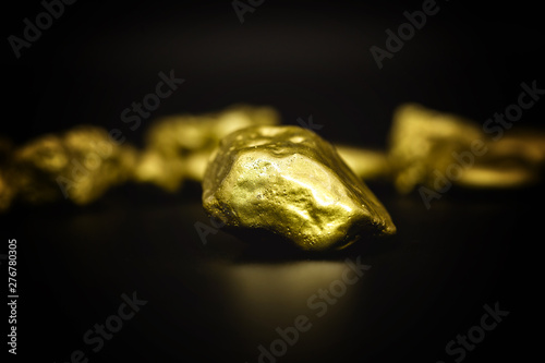 Golden stone in high resolution. Gold on black background isolated. Concept of luxury and wealth.