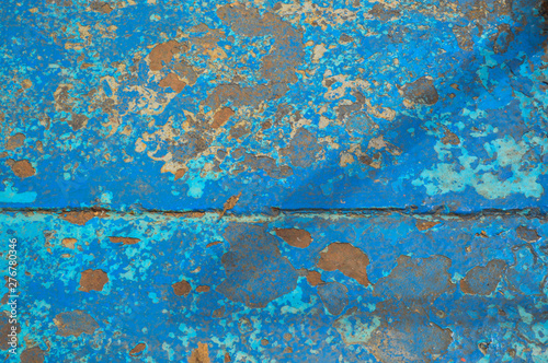 The texture of the iron metal painted blue paint old battered scratched cracked ancient rusty metal sheet wall with corrosion. The background