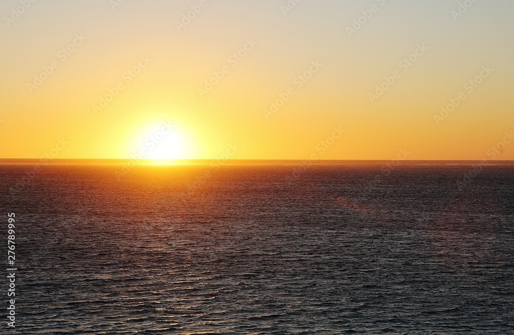 Fototapeta premium Sunset on the west coast of Australia. Moments of reflection. Calm sea. Bright sun.