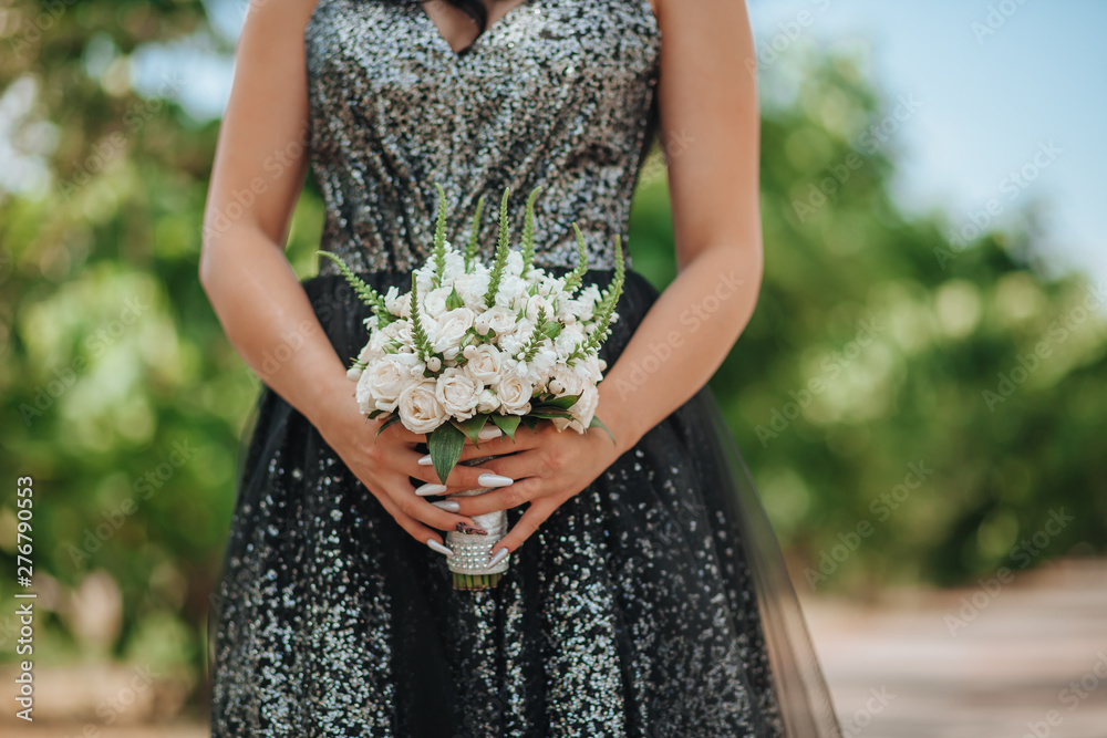 Obraz premium Girl in evening dress holding a bouquet of white roses