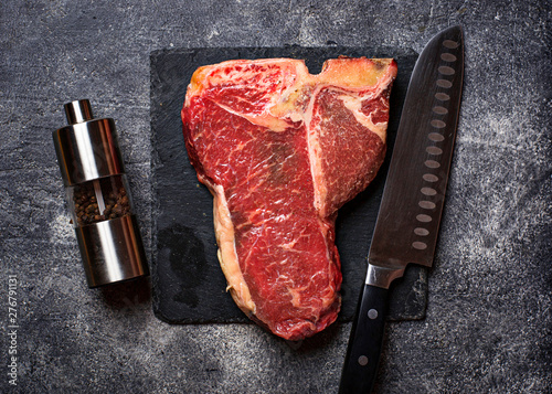 Raw T-bone steak on slate board