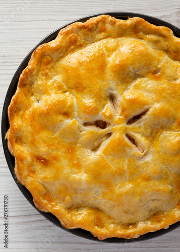 Homemade apple pie on a white wooden table, top view. Flat lay, overhead, from above. Close-up.