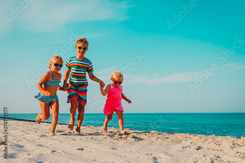 happy kids running on beach, boy and girls have fun at sea © nadezhda1906