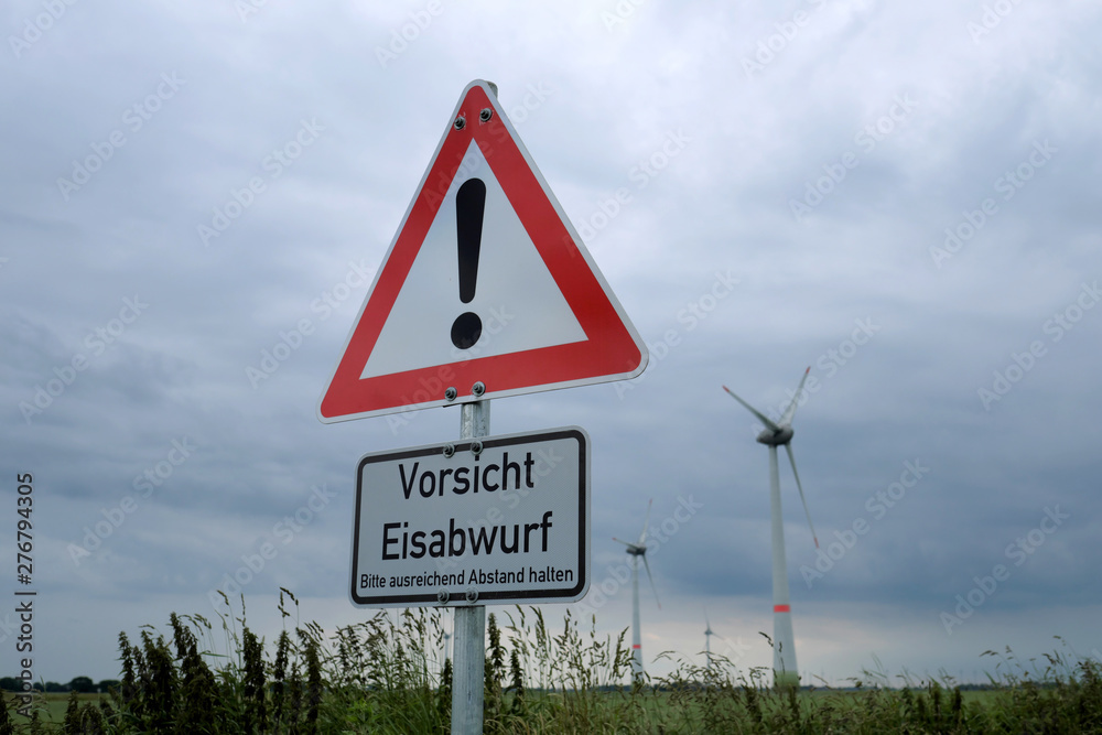 Verkehrszeichen Gefahrenstelle mit Zusatzschild Vorsicht Eisabwurf in der Nähe von Windrädern - Stockfoto Verkehrszeichen Gefahrenstelle mit Zusatzschild Vorsicht Eisabwurf in der Nähe von Windrädern - Stockfoto