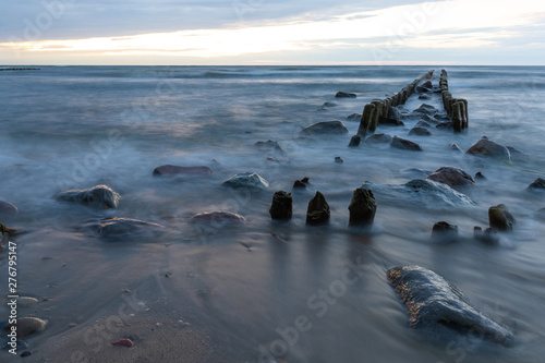 baltic sea with old breakwaters and stones on the coast on a long exposure