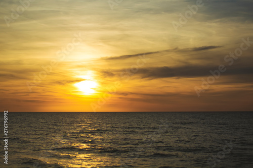 Beautiful fiery sunset sky on the beach. Sunrise over the sea and beautiful cloudscape. © lastfurianec