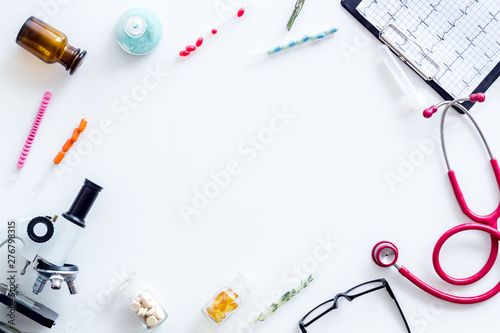 Doctors desk in laboratory with microscope, stethoscope, cardiogram frame for research white background top view mock up