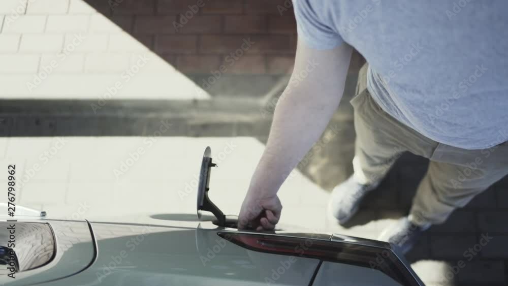Man fills his car with gasoline at night at gas station Man fills his car with gasoline at night at gas station
