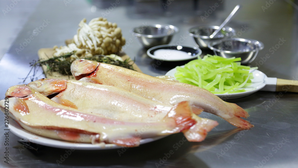 Fish preparation kitchen restaurant, salmon, uncooked, cook and vegetables Fish preparation kitchen restaurant, salmon, uncooked, cook and vegetables