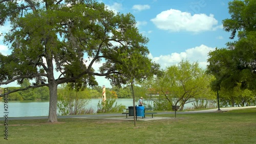 Retired Man Running In a Scenic Park Setting along a San Antonio TX Lakefront Pathway on a Sunny Day in Texas  photo