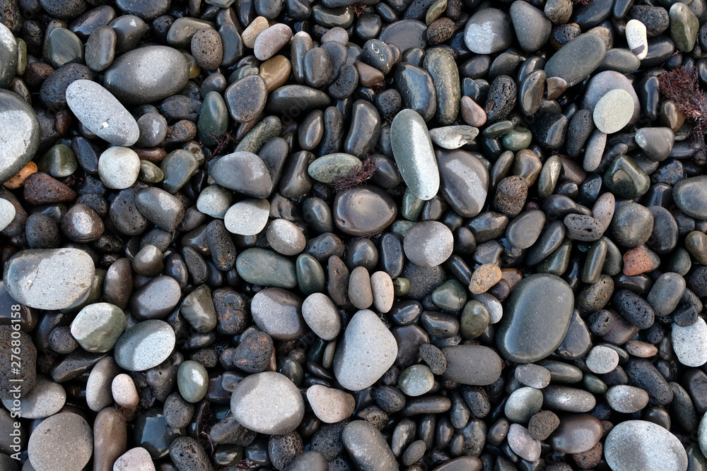 A selection of wet and dry round stones, pebbles on the beach. A selection of wet and dry round stones, pebbles on the beach.