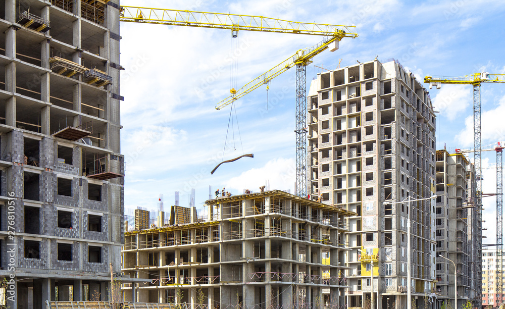  Construction site with cranes and building with blue sky  and clouds 