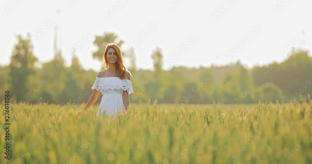 Beautiful woman walks in the field, the girl smiles. Field with wheat in summer. Circular motion of the camera. Beautiful woman walks in the field, the girl smiles. Field with wheat in summer. Circular motion of the camera.
