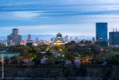 Osaka castle with cherry blossom and business district in background at Osaka, Japan.