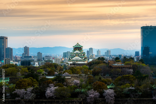 Osaka castle with cherry blossom and Center business district in background at Osaka, Japan.