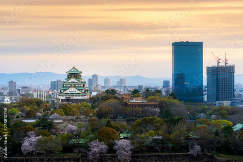 Osaka castle with cherry blossom and Center business district in background at Osaka, Japan.