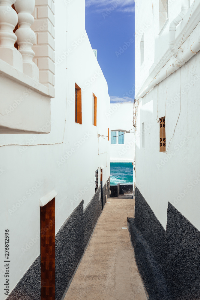 Alleyway of a tourist destination, white houses on the coastline. 