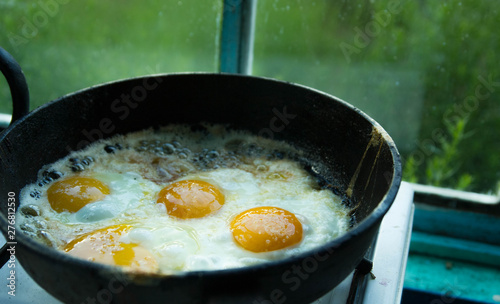 four fried eggs in butter in a pan in the village