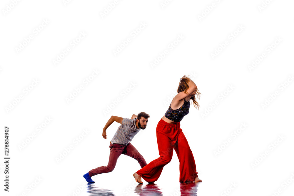 Handsome boy dancing with a slim, attractive girl isolated on white