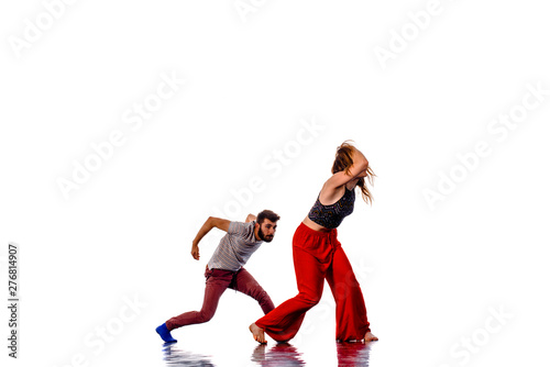 Handsome boy dancing with a slim, attractive girl isolated on white © qunica.com