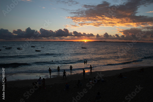 Sunset on the beach, with silhouettes of people at the seaside